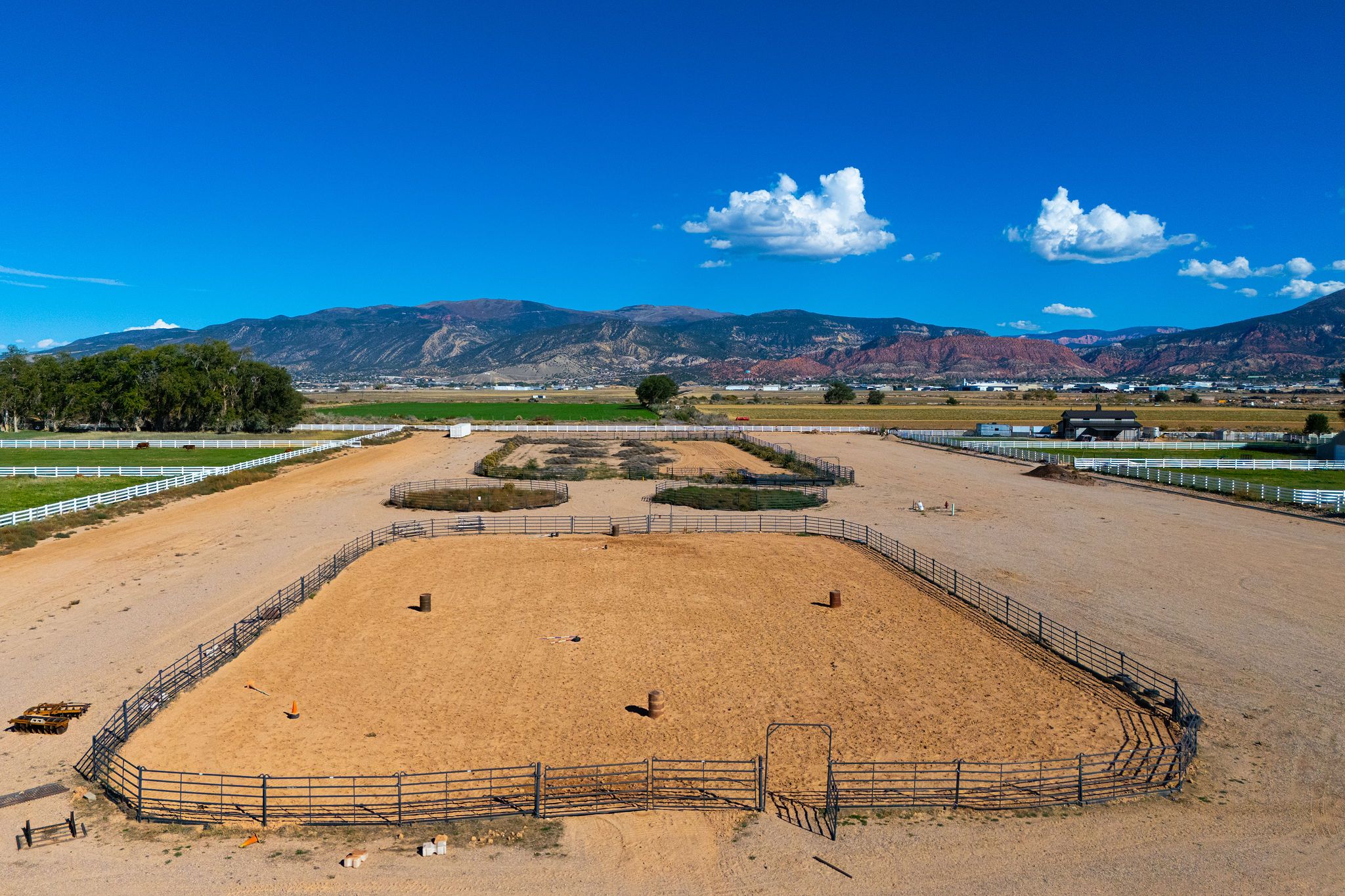 Aerial view of Equestrian Pointe in Cedar City, Utah, with the riding arena, pastures and mountains beyond