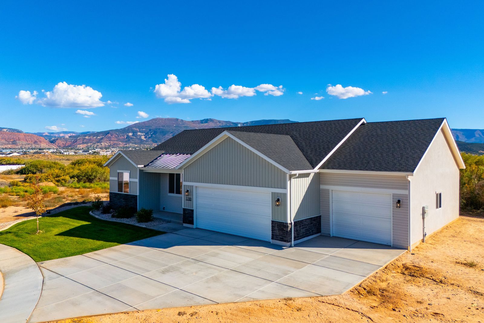 Front exterior of 1230 N 3625 West Circle, a single-level home with a three-car garage and mountain views